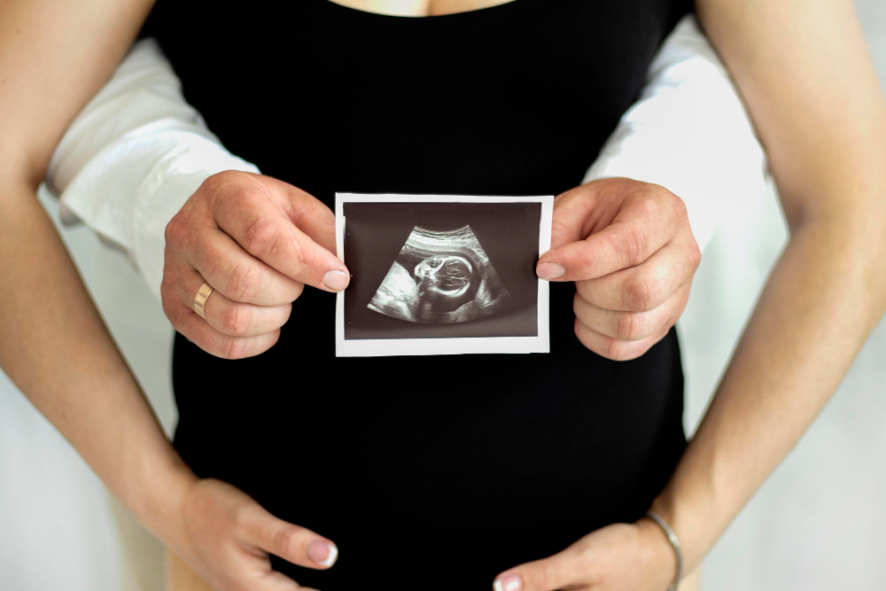 A couple holding a baby bump.